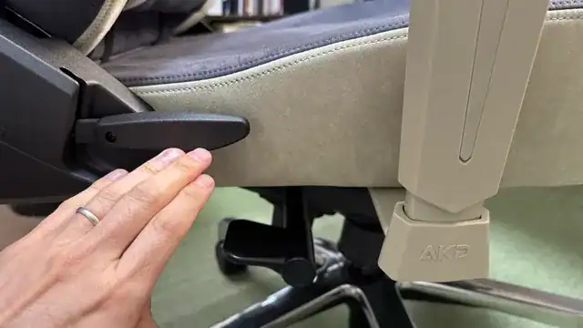AKRacing Faura 座面横のリクライニングレバーを操作する様子